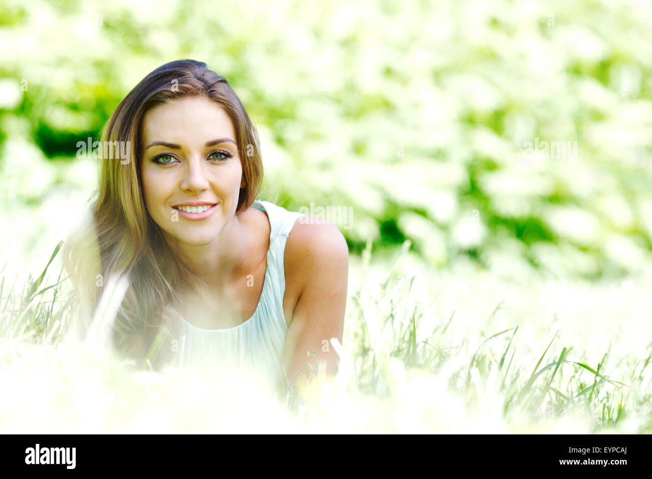 young woman in blue dress lying on grass Stock Photo - Alamy