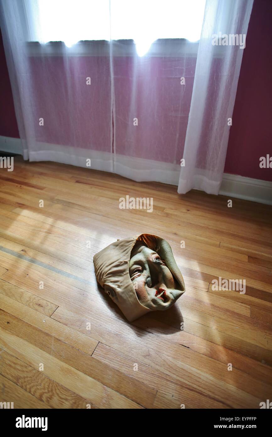A crumpled up inside out Bill Clinton halloween mask on a floor. Stock Photo