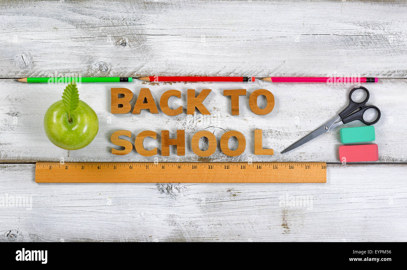 Wooden letters spelling back to school with green apple, pencils