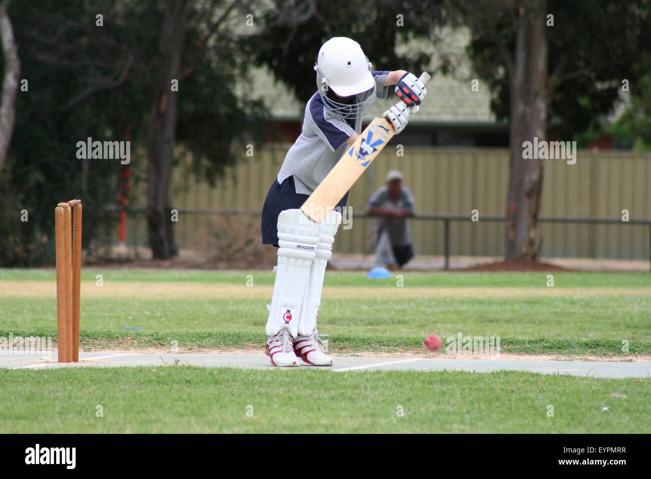 A young cricketer hits the ball during a junior game of cricket in