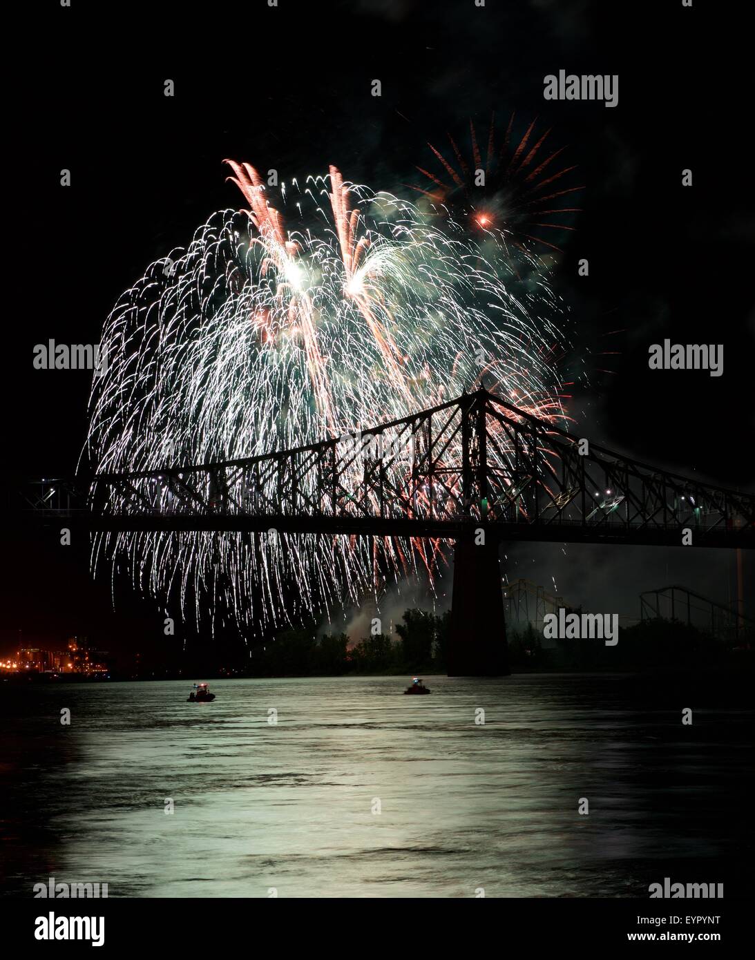 Red fireworks explode in Montreal with bridge silhoutte in dark sky,Montreal fireworks festival, fireworks explode, New Year, fi Stock Photo