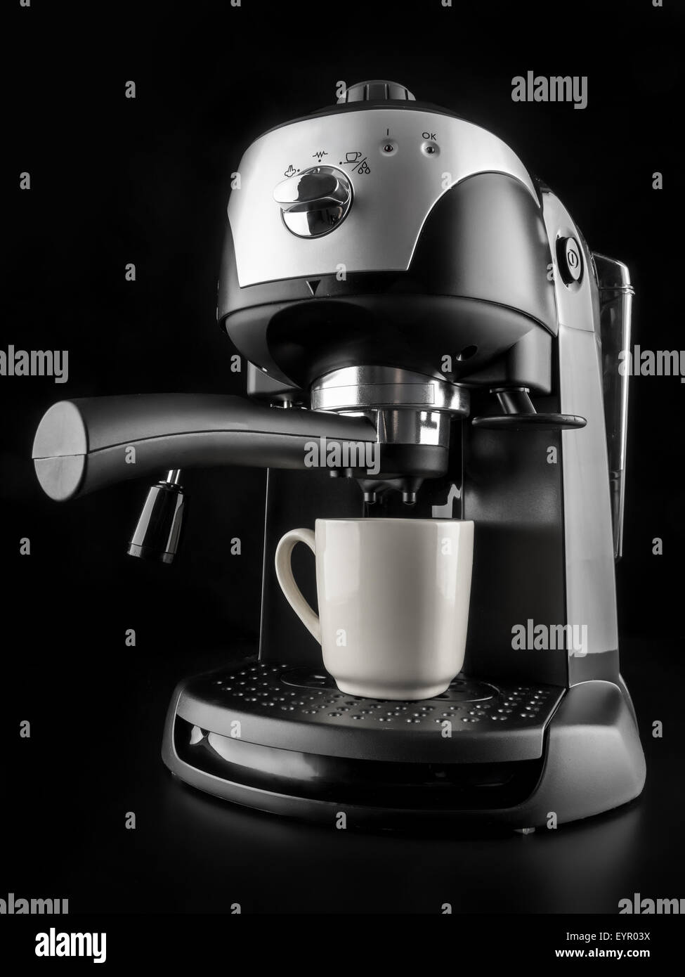 Modern coffee machine with white mug shot on black background Stock Photo
