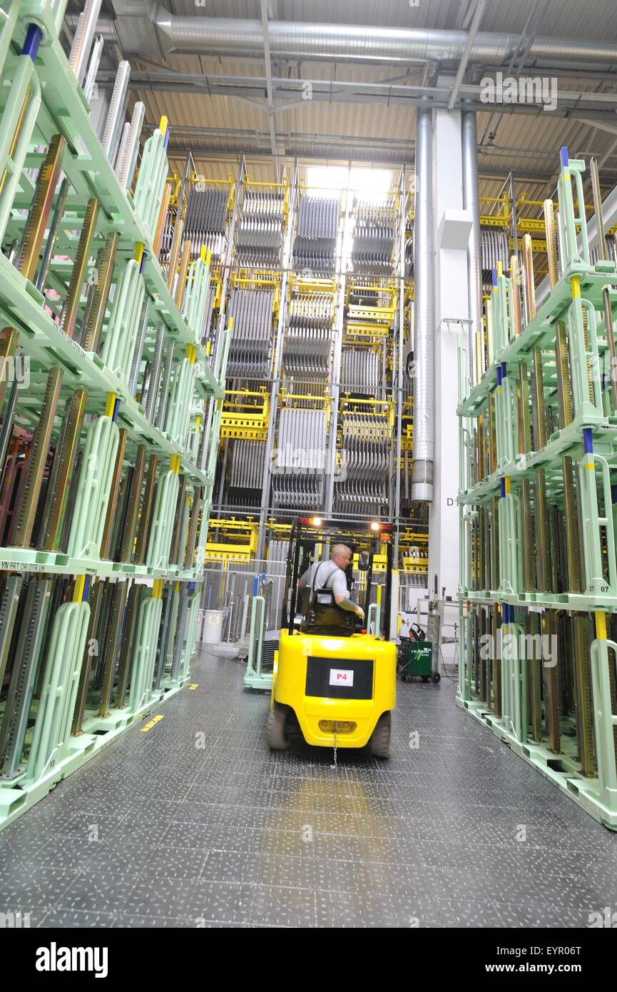 Inside a modern car factory, vehicles and parts move through the production process, fork truck in the warehouse Stock Photo