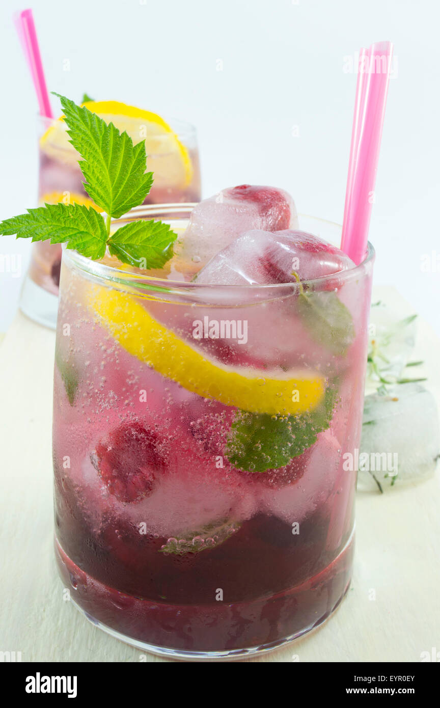 Natural homemade red forest fruit iced-T juice with ice, lemon and sliced fruits Stock Photo