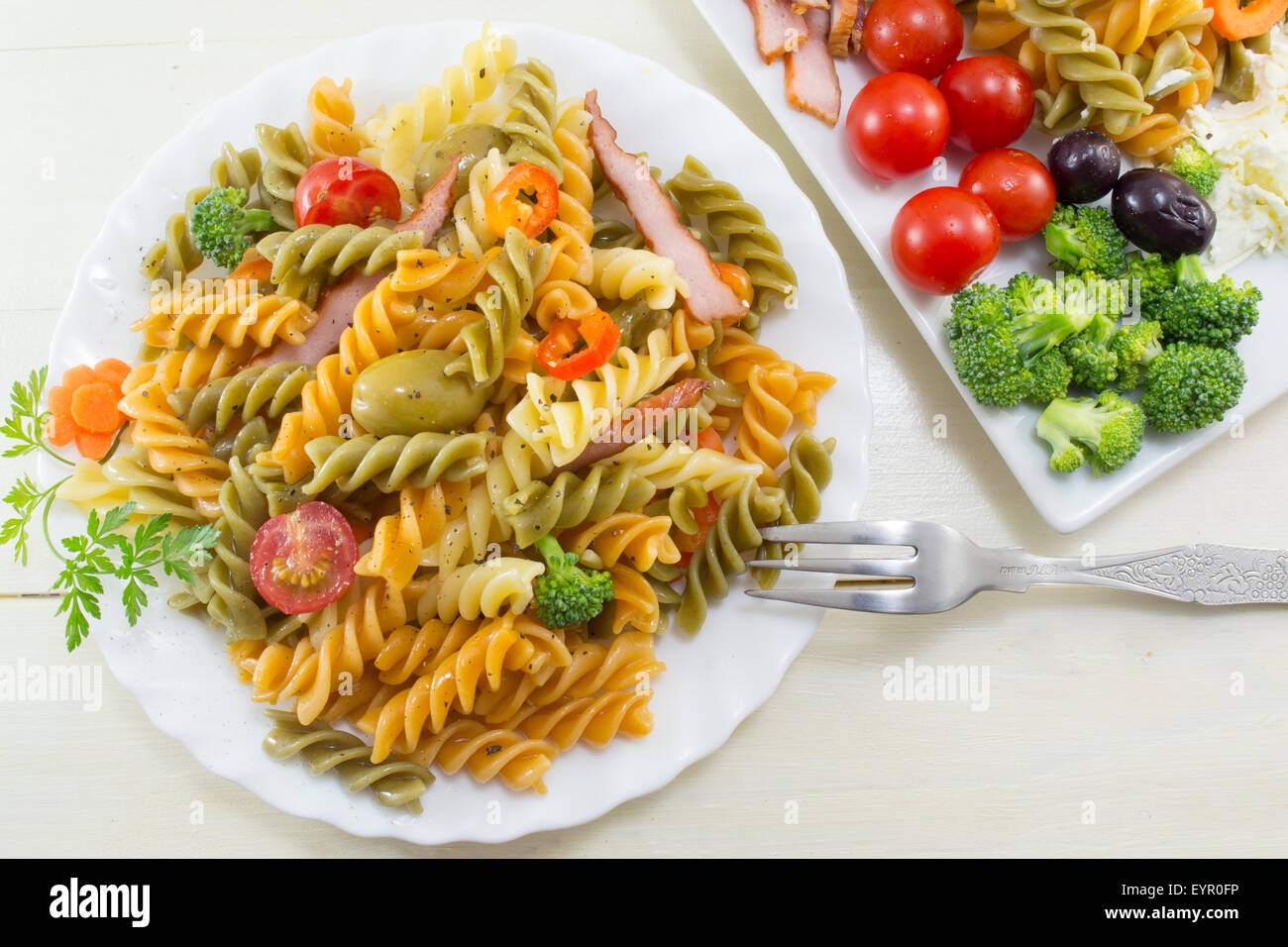 Pasta meal cooked with vegetables with fresh vegetables served in white dishes Stock Photo