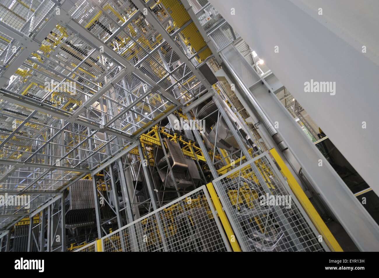 Inside a modern car factory, vehicles and parts move through the production process, huge storage area Stock Photo