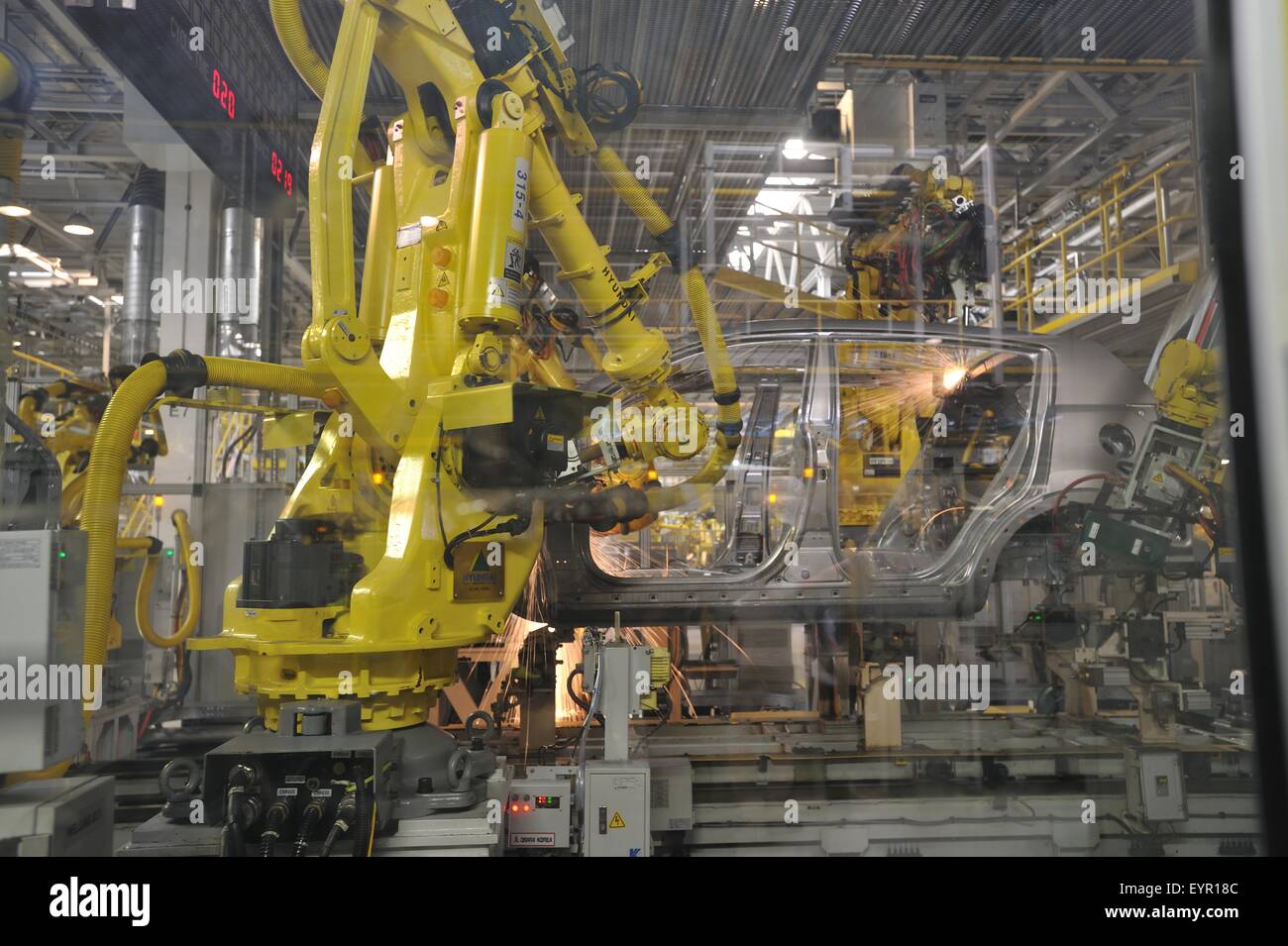 Inside a modern car factory, vehicles and parts move through the production process, welding robots at work Stock Photo