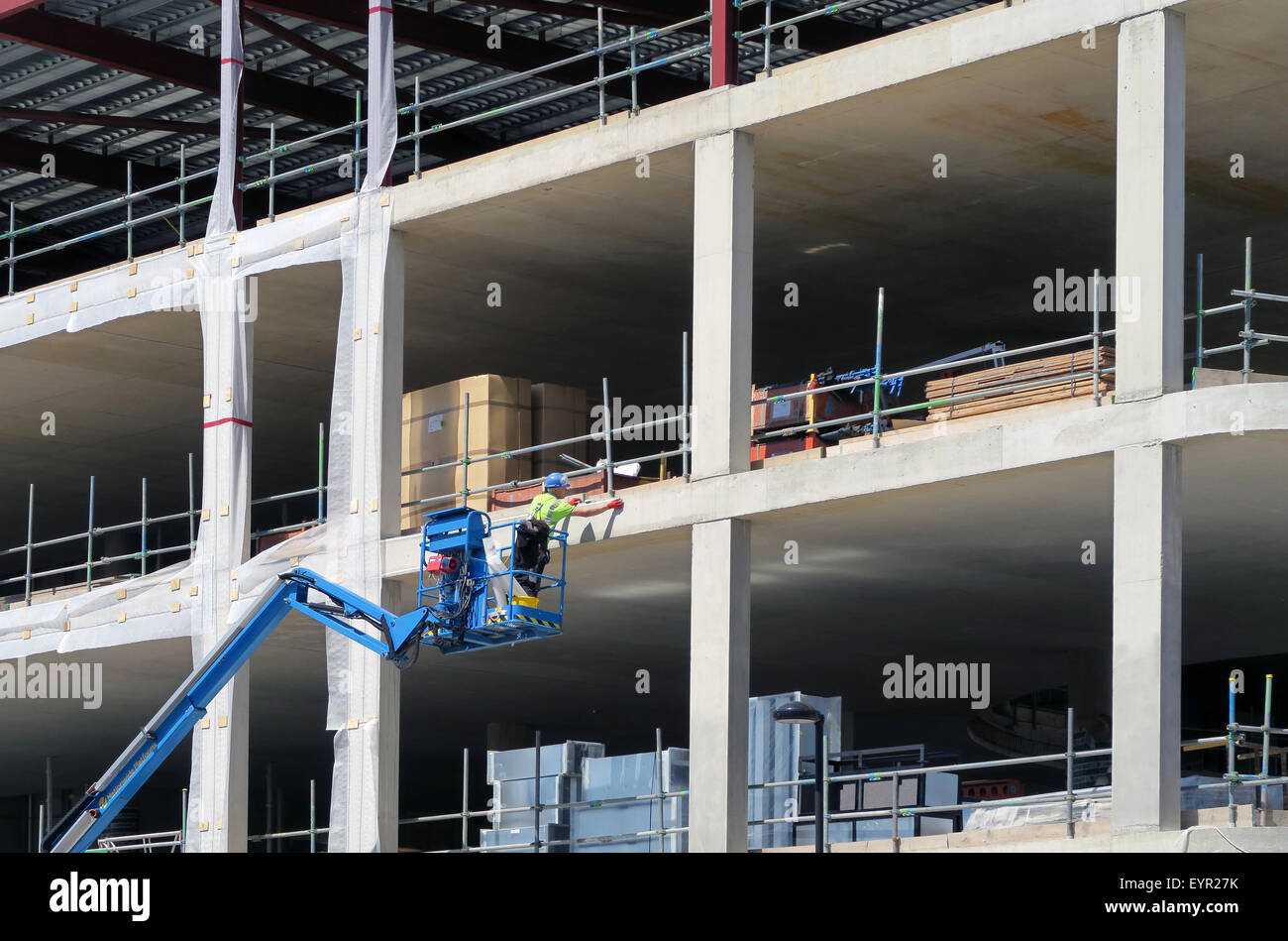 Construction worker using platform picker on new build Stock Photo Alamy