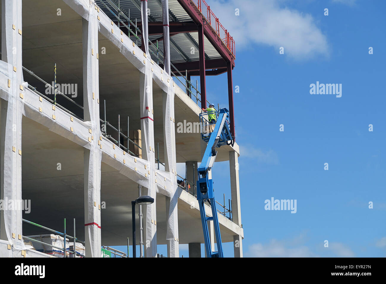 Construction worker using platform picker on new build Stock Photo Alamy
