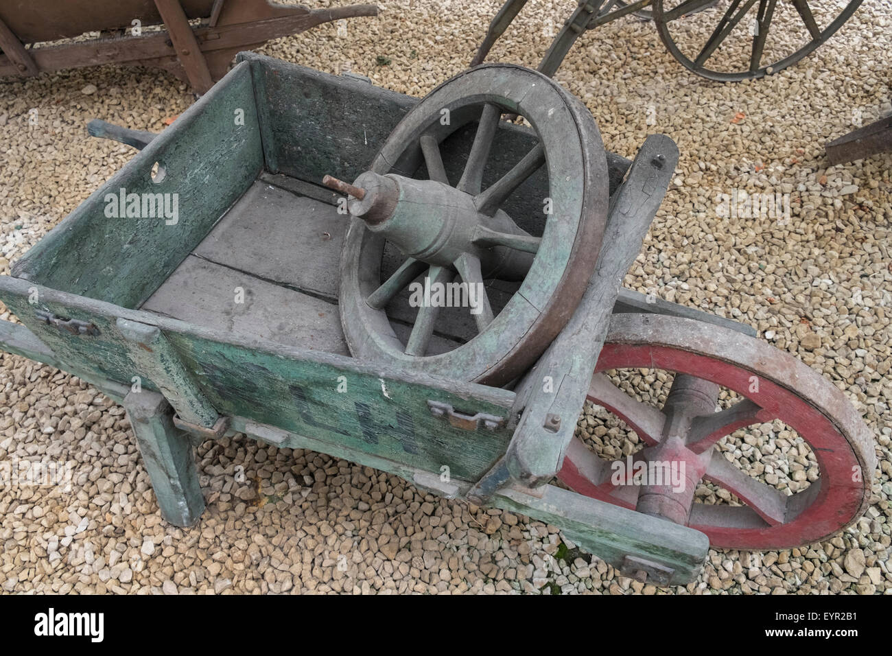 Old style wooden barrow and spare wheel. Stock Photo