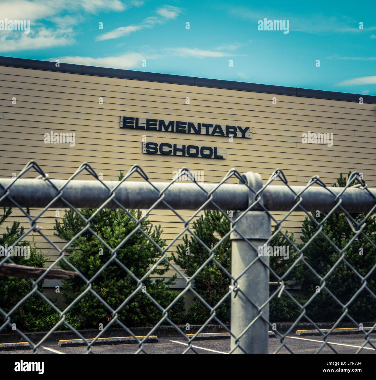 Typical USA Elementary School With Chain Link Fence In Foreground Stock Photo