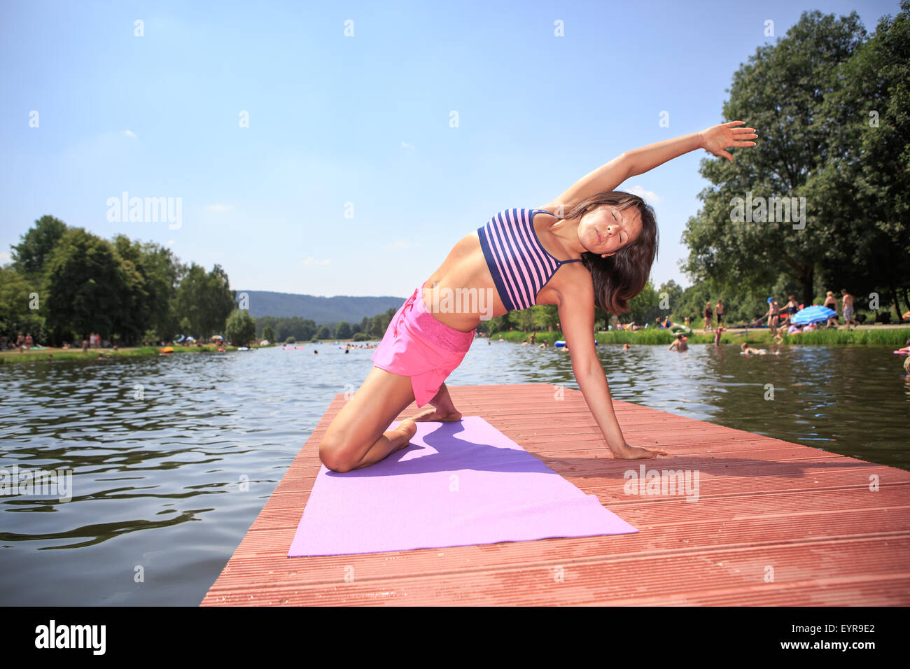 woman making yoga exercise at a lake Stock Photo - Alamy