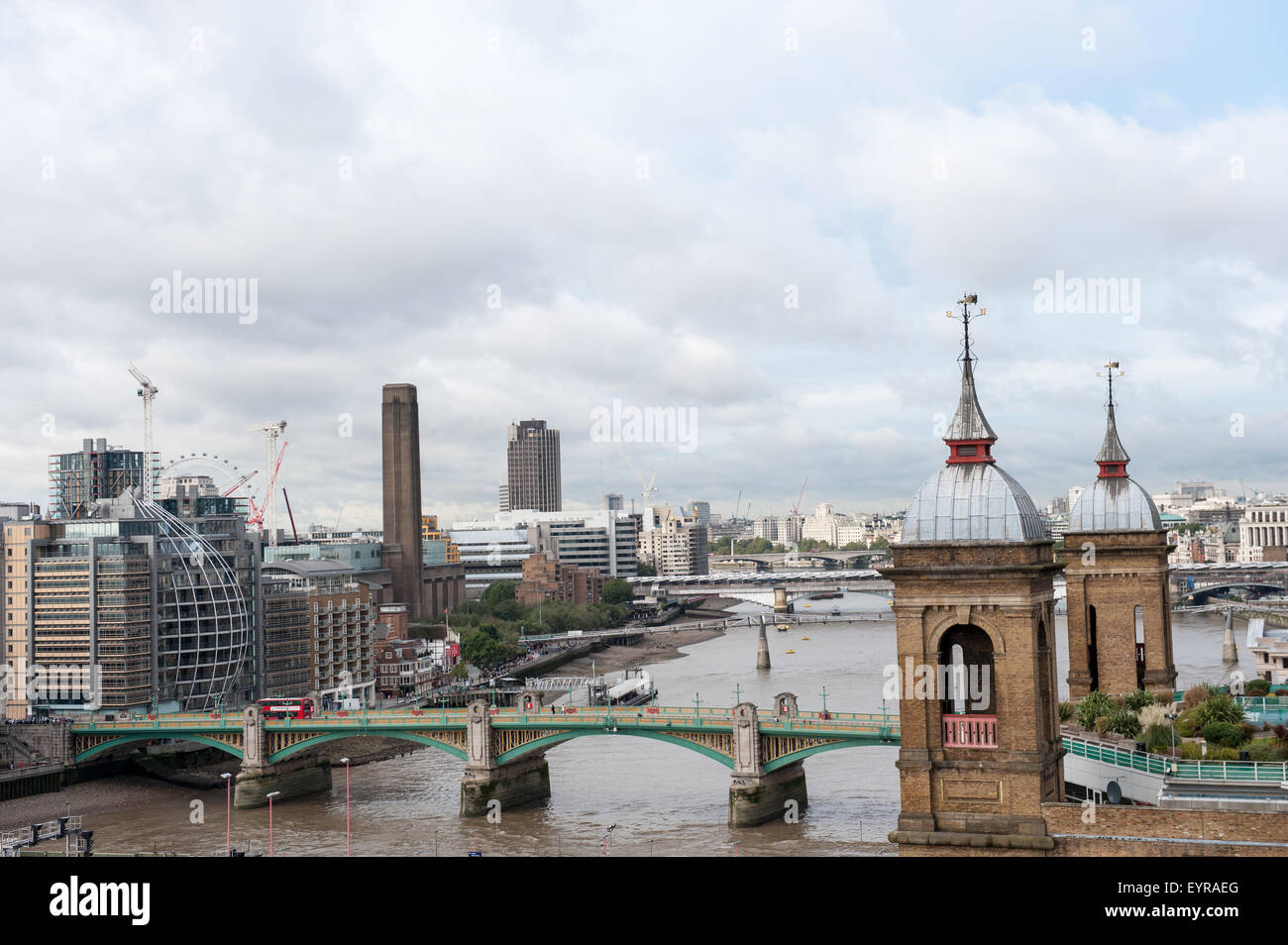 Southwark bridge, London, England. High view of River Thames with modern buildings and old towers, green and yellow Southwark Brdge Stock Photo