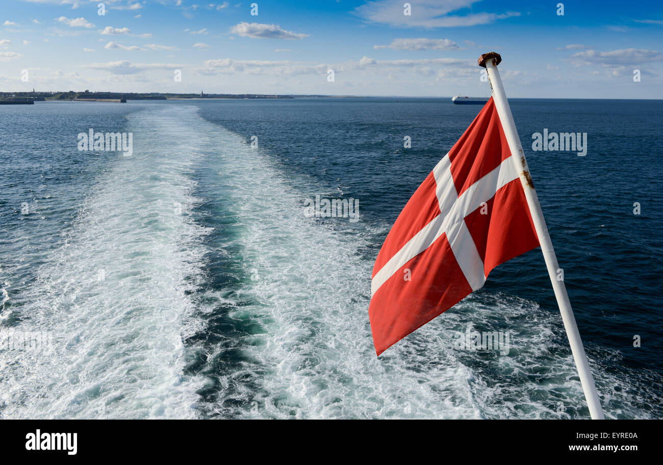 The Danish national flag flying from the ensign staff of a Danish ship Stock Photo