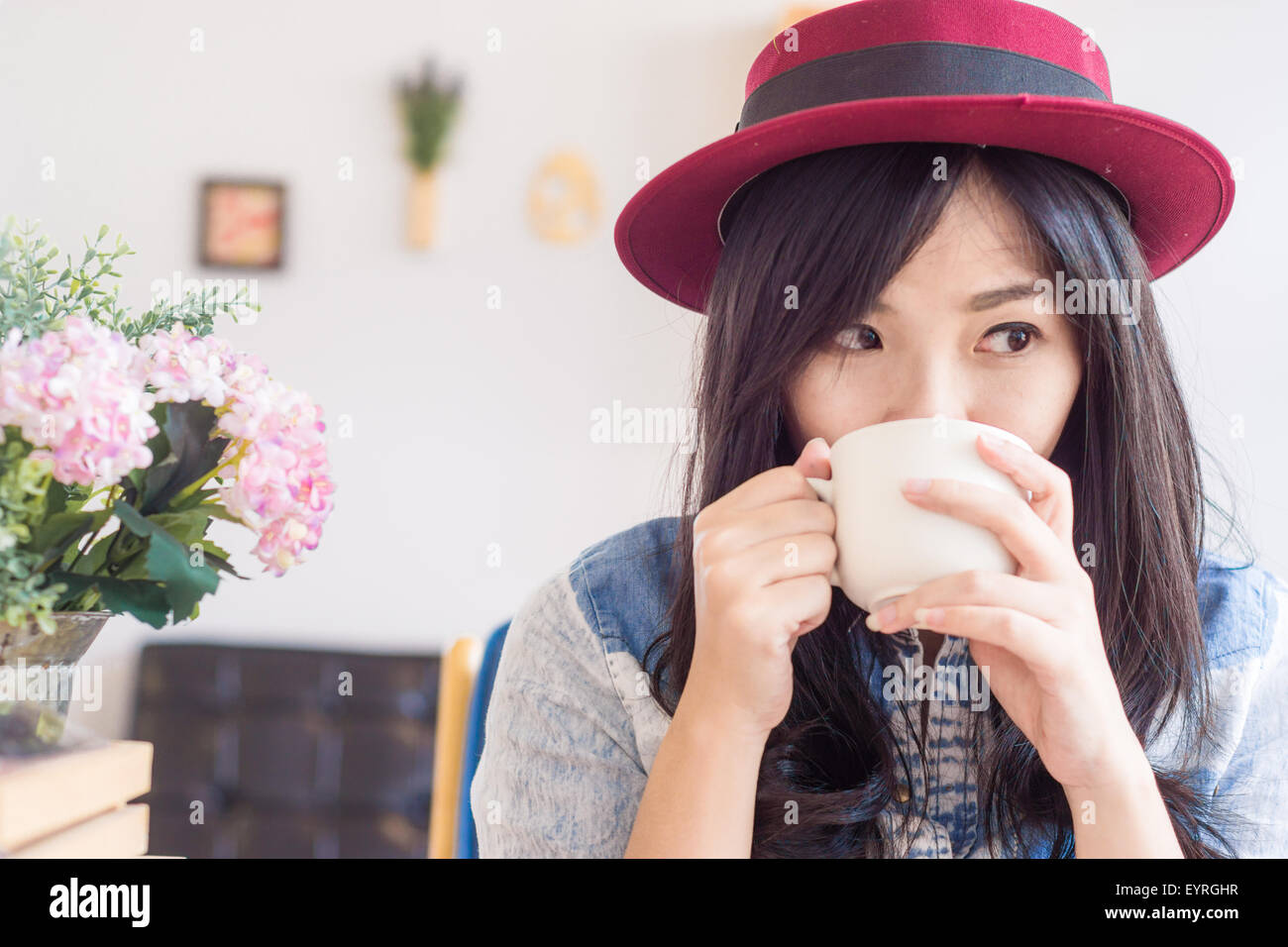 Beautiful asian woman drinking coffee in vintage cafe , Fashionable holding coffee Stock Photo