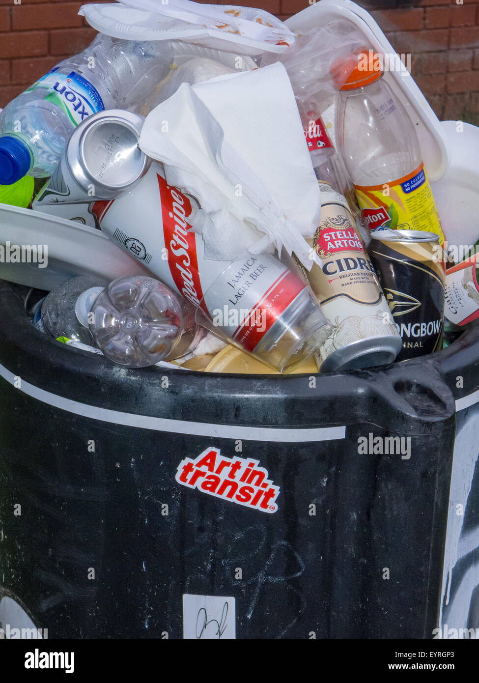 Notting Hill, London, England. Over flowing rubbish bin, with 'Art in Transit' sticker. Carnival. Stock Photo