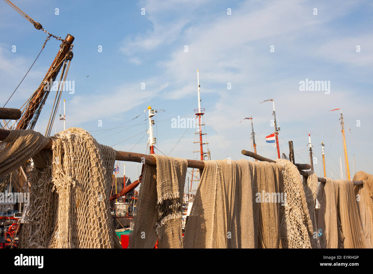 Fishing nets drying in the sun alongside the harbour Stock Photo