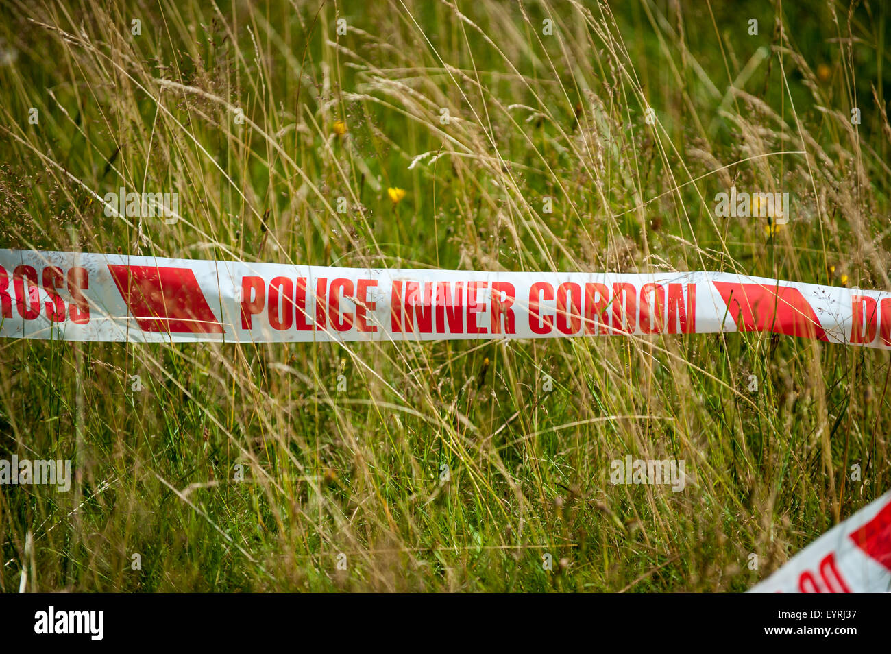 Rural England. Red and white Police tape in a field. Stock Photo