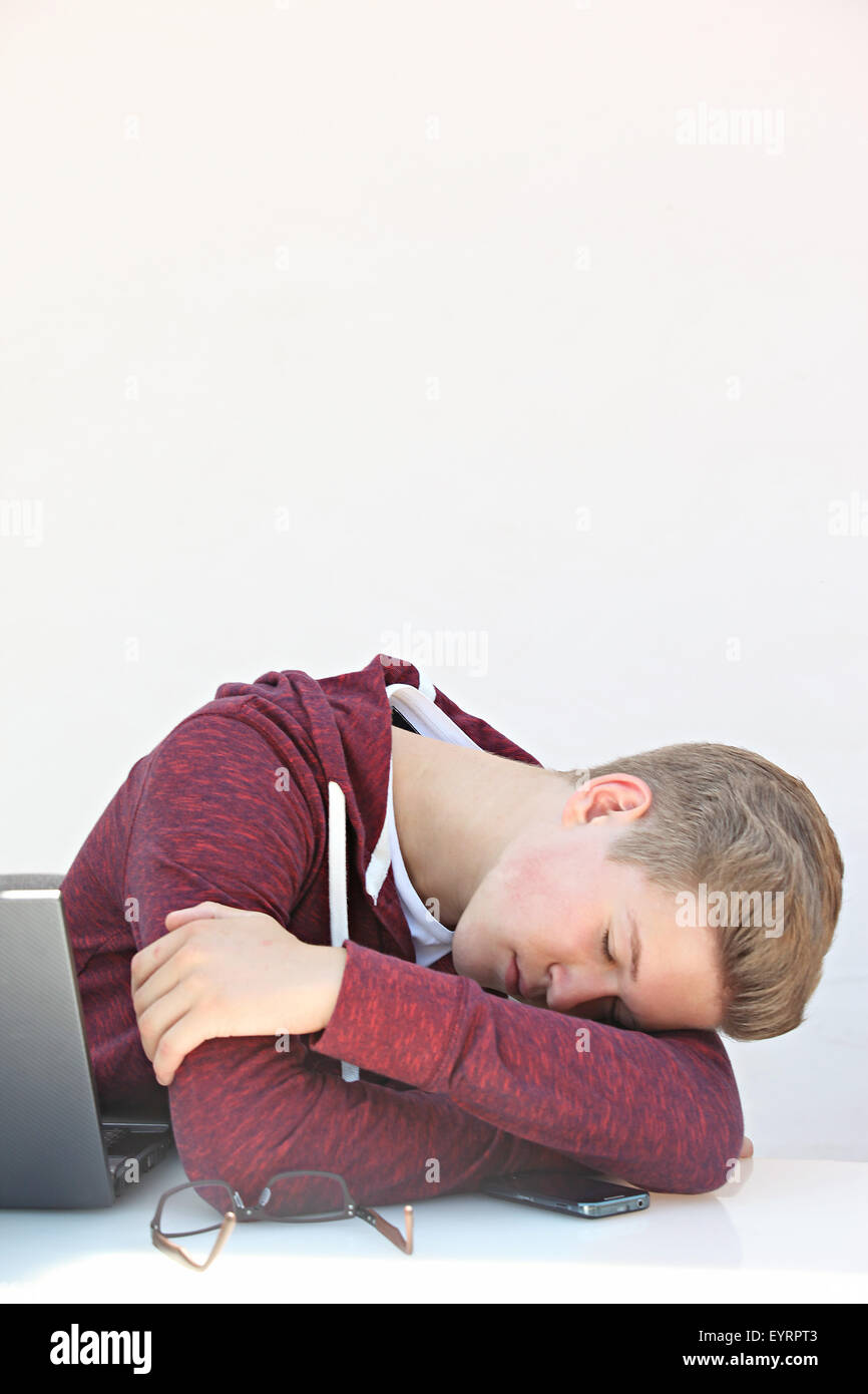 Youngster with laptop before white background sleeps Stock Photo