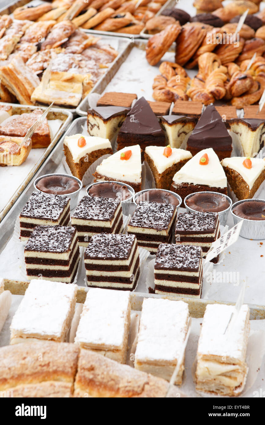 Assortment of many pastries and desserts displayed on bakery trays Stock Photo