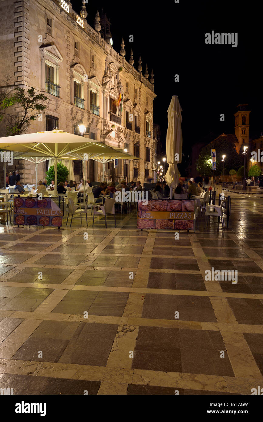 Outdoor restaurant tables at Plaza Nueva and Santa Ana at night with Royal Chancery of Granada Stock Photo