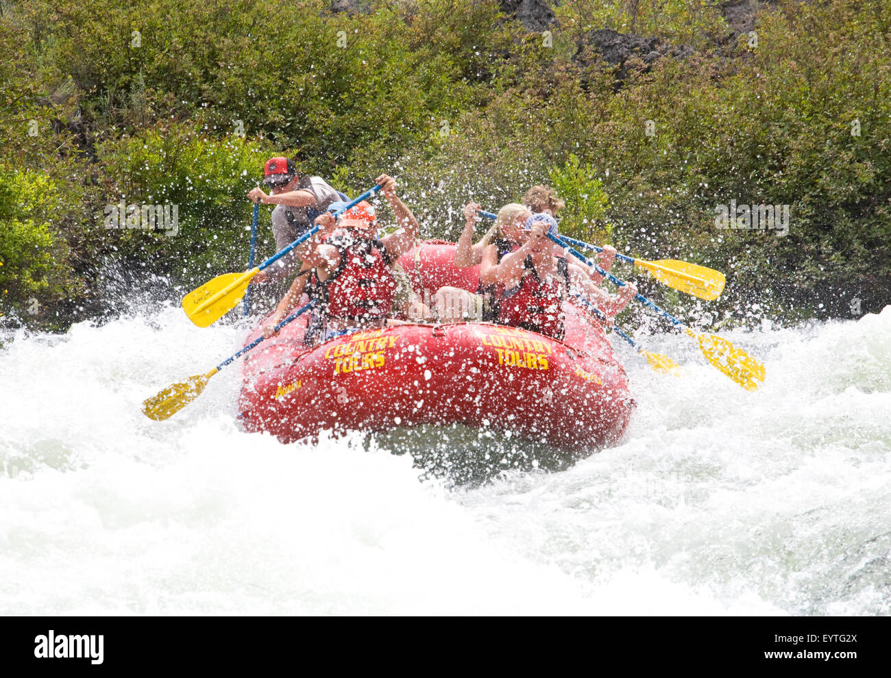 Whitewater rafters on Oregon's Deschutes River cool off quickly as they navigate a class five rapid near the resort city of Bend Stock Photo