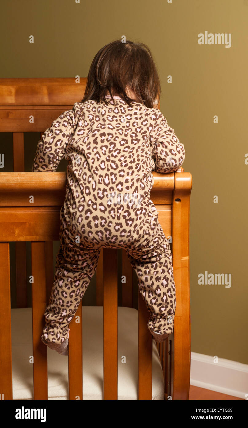 Toddler climbing out of her crib Stock Photo Alamy