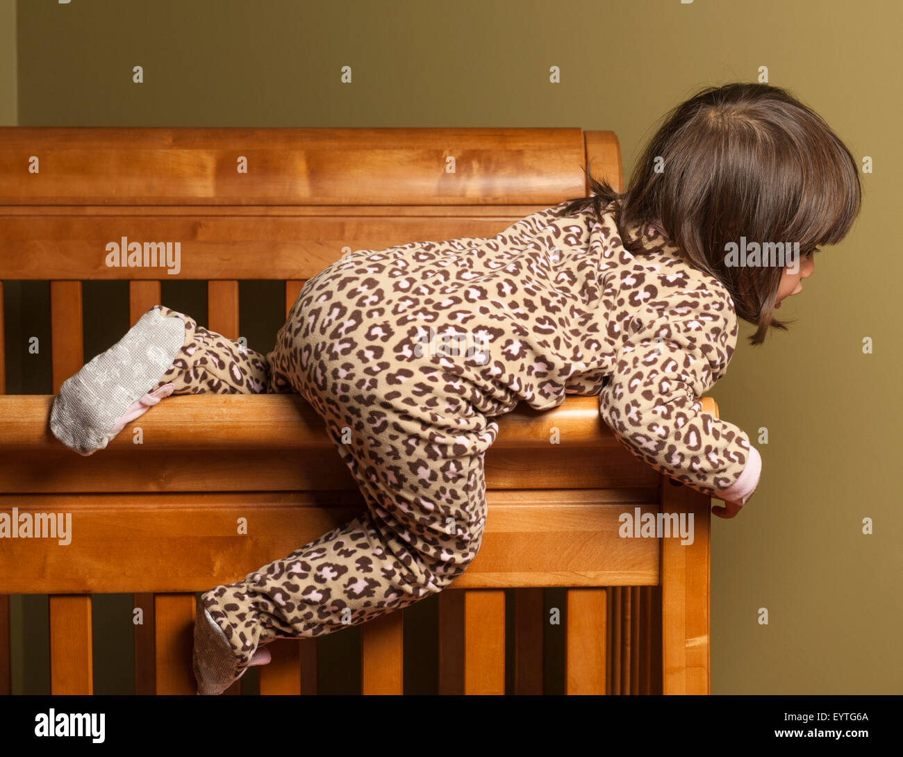 Toddler climbing out of her crib Stock Photo Alamy