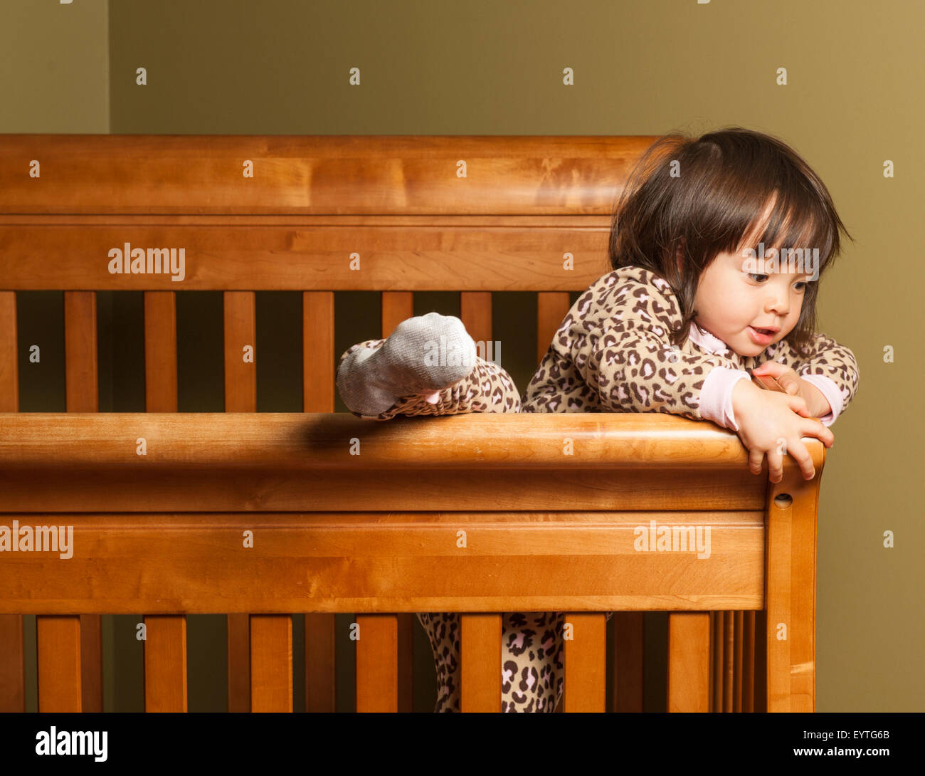 Toddler climbing out of her crib Stock Photo Alamy