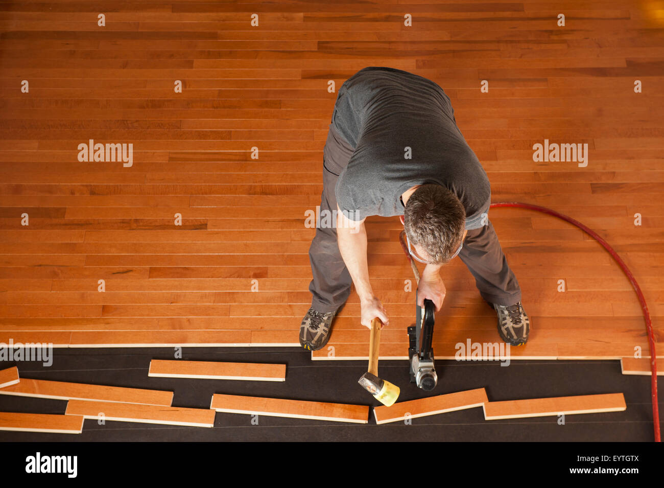 Top View Of A Man Installing Planks Of Hardwood Floor Stock Photo