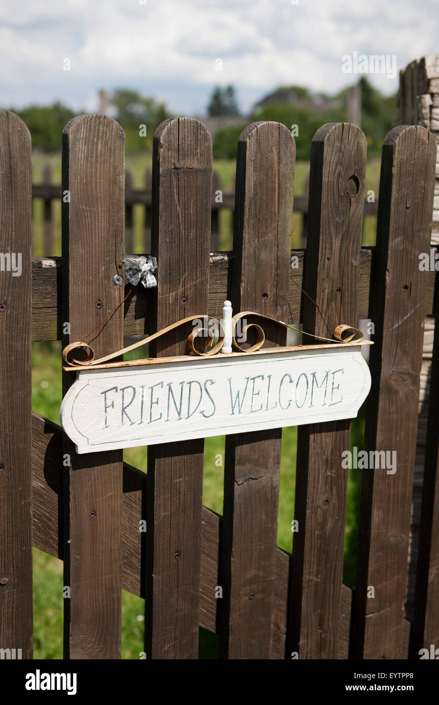 Wooden garden gate with sign 'Friends welcome' Stock Photo