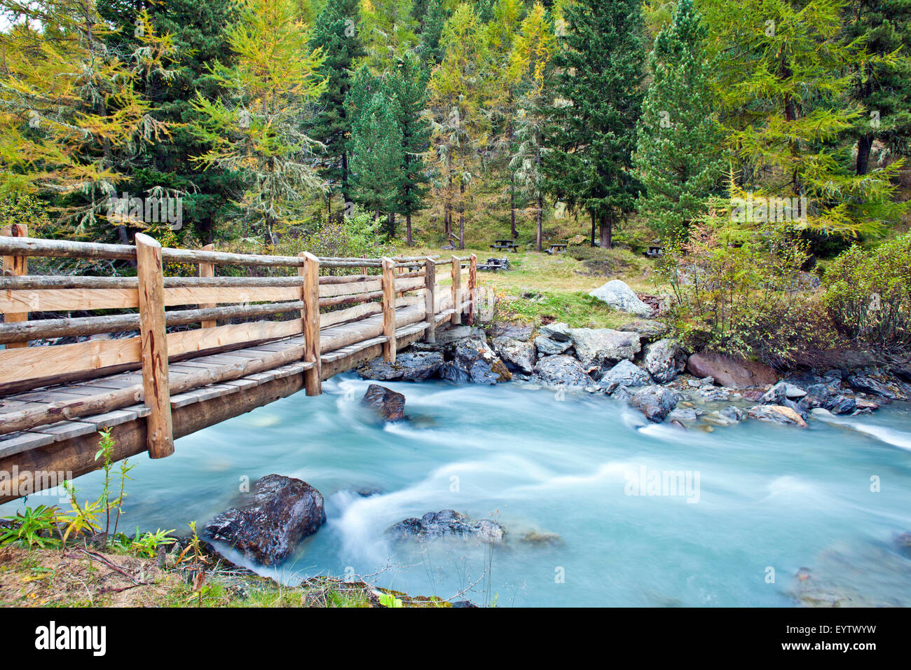 Autumn wood with footbridge over brook Stock Photo