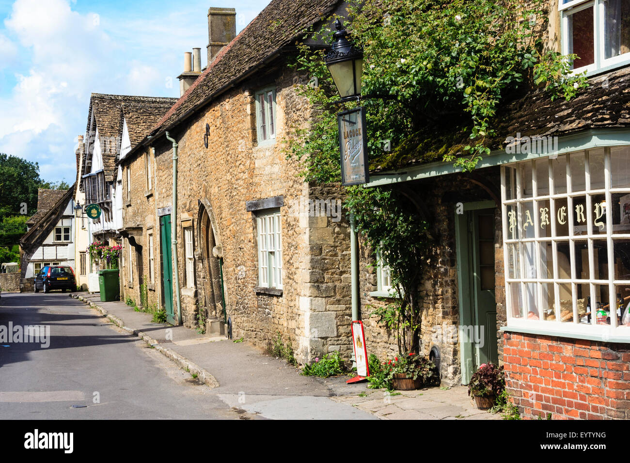 England, Lacock, Cotswolds. View along Church Street, 15th century - 18th century Cotswold stone houses and village bakery. Picturesque view. Stock Photo
