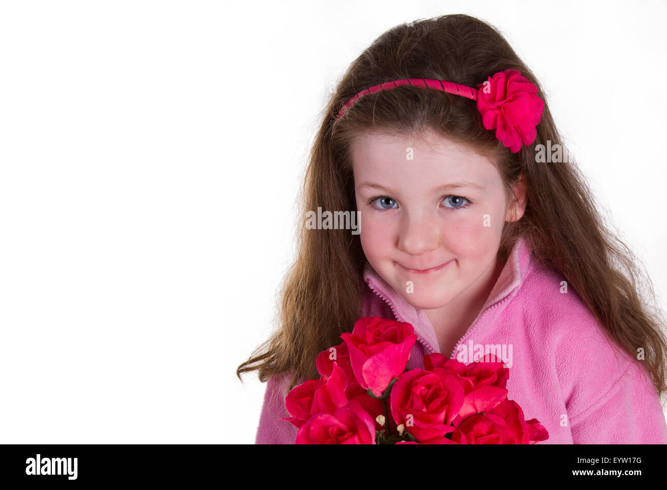 Young girl holding a bunch of artificial roses and looking at the camera Stock Photo