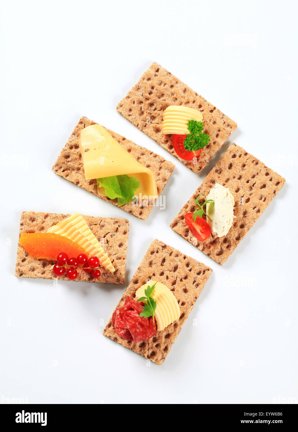 Whole grain crisp bread slices with various toppings Stock Photo