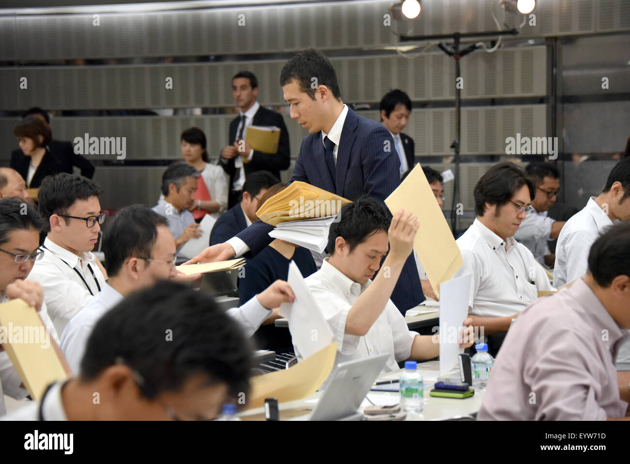 Tokyo, Japan. 4th Aug, 2015. A Toyota employee distributes printed document to members of the media prior to the automakers report of its financial results at its head office in Tokyo on Tuesday, August 4, 2015. Otake said the Japanese automakers group net profit rose 10.0 percent from a year earlier to a record 646.39 billion yen for the April to June period of 2015. The automaker's consolidated operating profit climbed 9.1 percent to a record 756.00 billion yen and sales rose 9.3 percent to 6.99 trillion yen. Credit:  Natsuki Sakai/AFLO/Alamy Live News Stock Photo