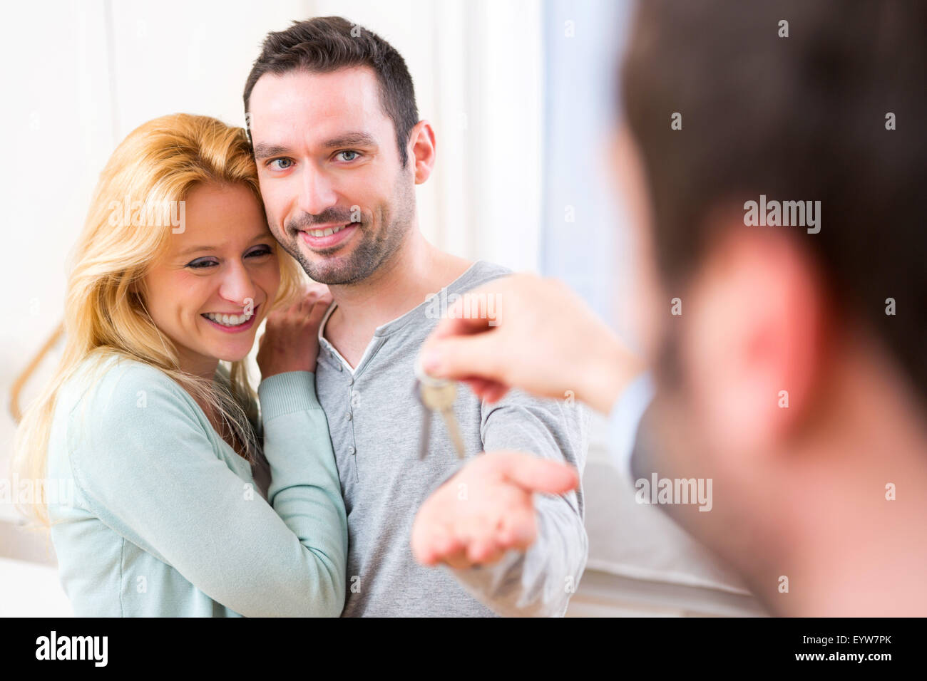 View of Real estate agent delivers keys of new house to young couple ...
