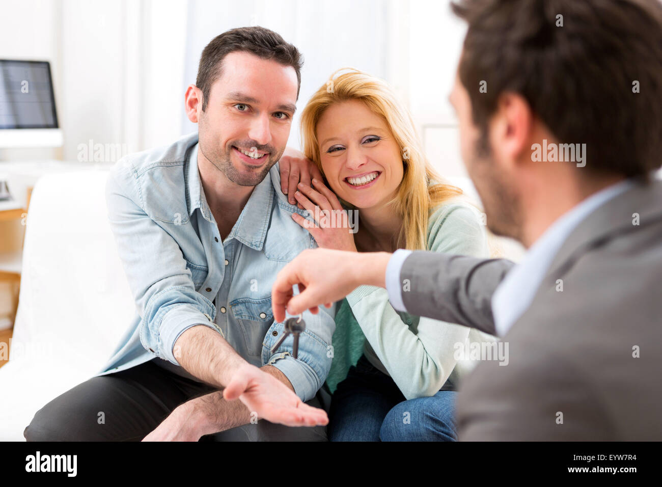 View of Real estate agent delivers keys of new house to young couple ...