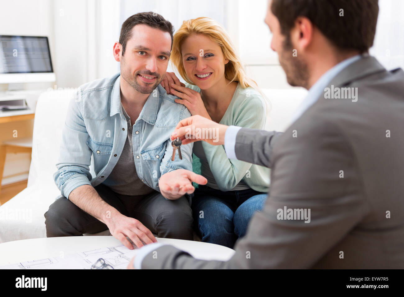 View of Real estate agent delivers keys of new house to young couple ...
