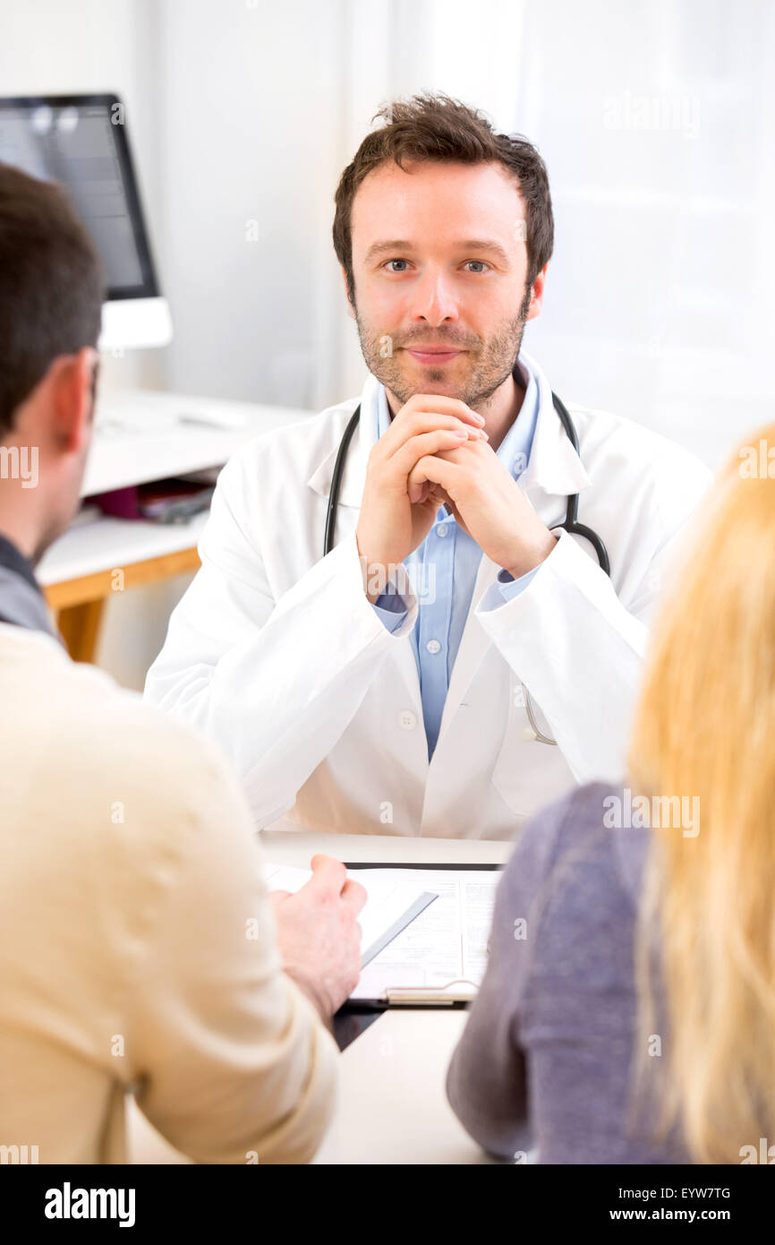 Doctor advising couple hi-res stock photography and images - Alamy