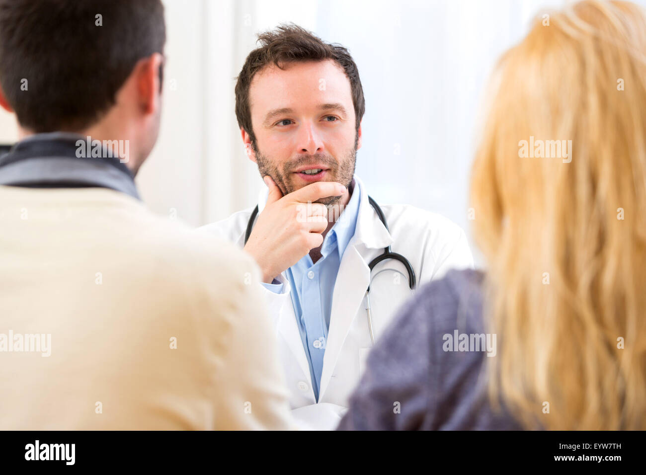 Doctor advising couple hi-res stock photography and images - Alamy