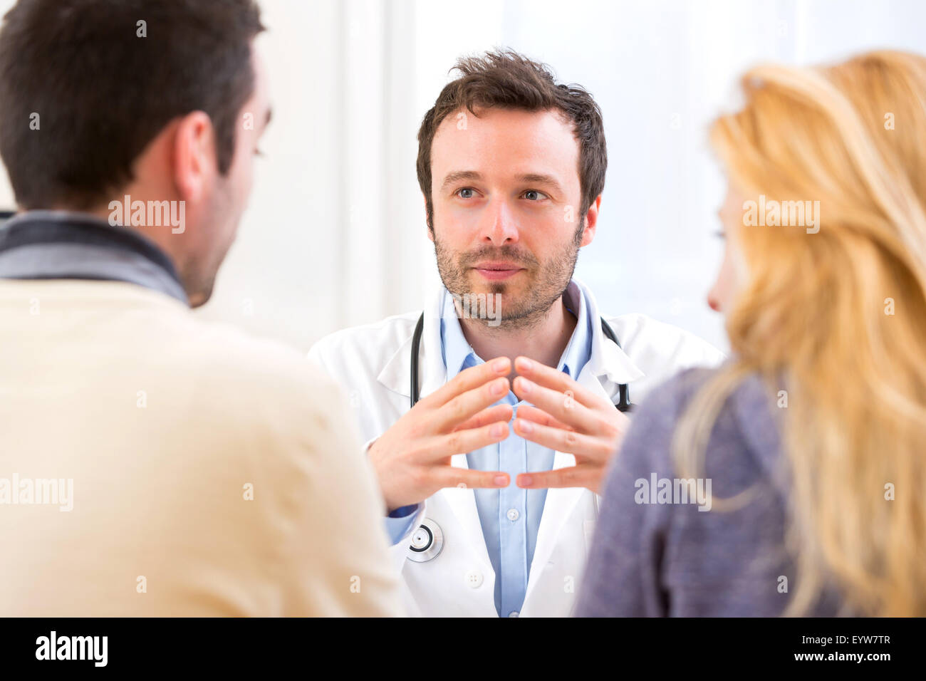 Doctor advising couple hi-res stock photography and images - Alamy