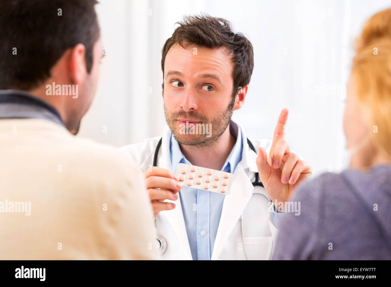 Doctor advising couple hi-res stock photography and images - Alamy