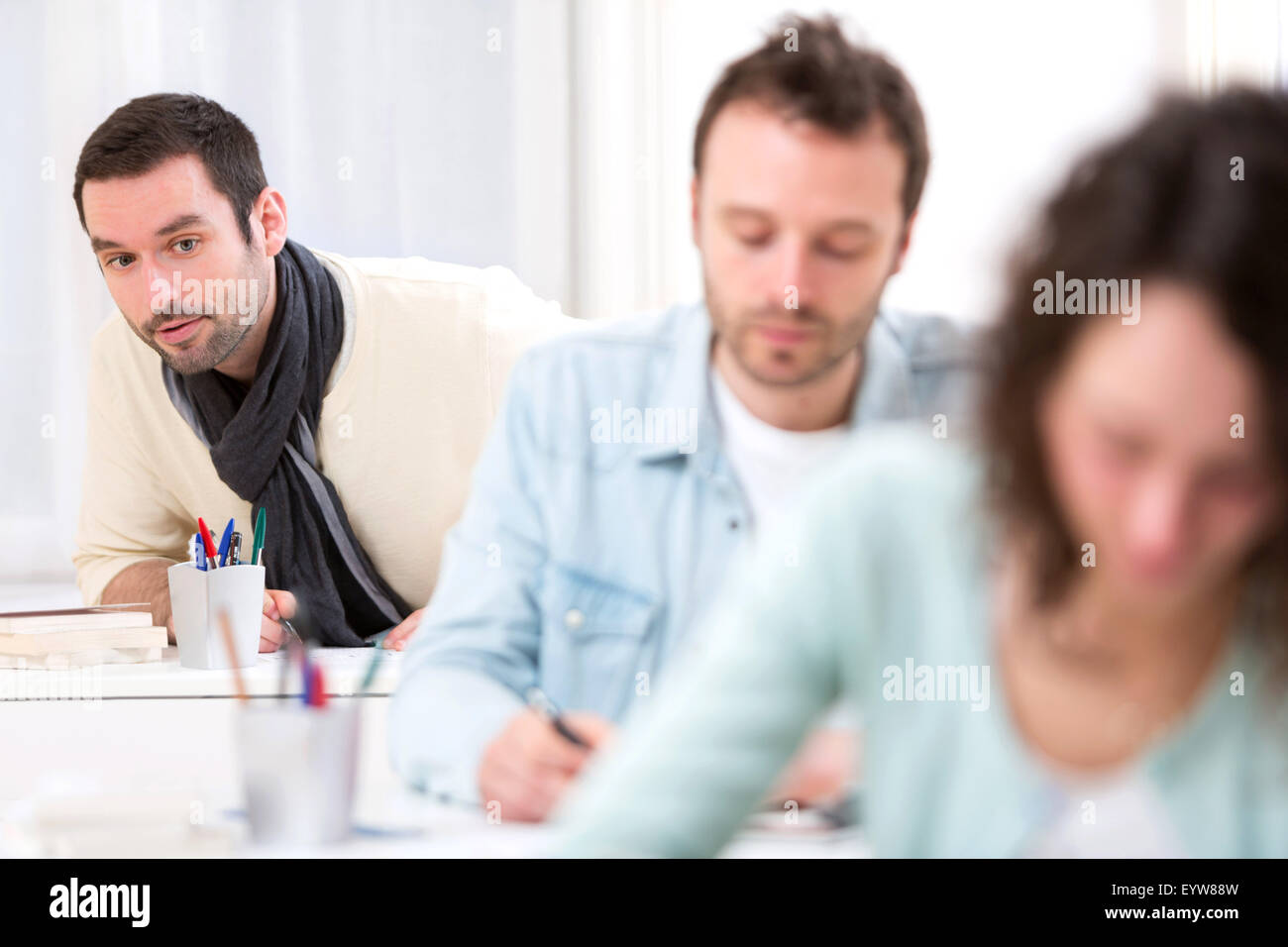 View of a Classmate in the background trying to cheat Stock Photo