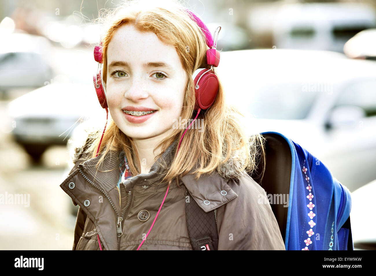 Girl with schoolbag and headphones on the way to school Stock Photo