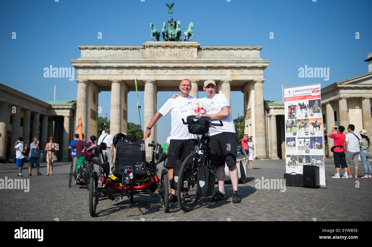 Amateur athletes Karl Grandt (L) from Flensburg and Sven Marx from Berlin pose in front of the Brandenburg Gate promoting the bicycle event 'Inklusion braucht Aktion' (lit. inclusion needs action) in Berlin, Germany, 04 August 2015. With daily stages varying between 80 and 120 km, the 2,700 km tour will take the two men through various European cities and countries such as Flensburg, Berlin, Poland, the Czech Republic, Munich and Austria. Their final destination will be Rome, Italy, where they will have an audience with the Pope. Photo: BERND VON JUTRCZENKA/dpa Stock Photo