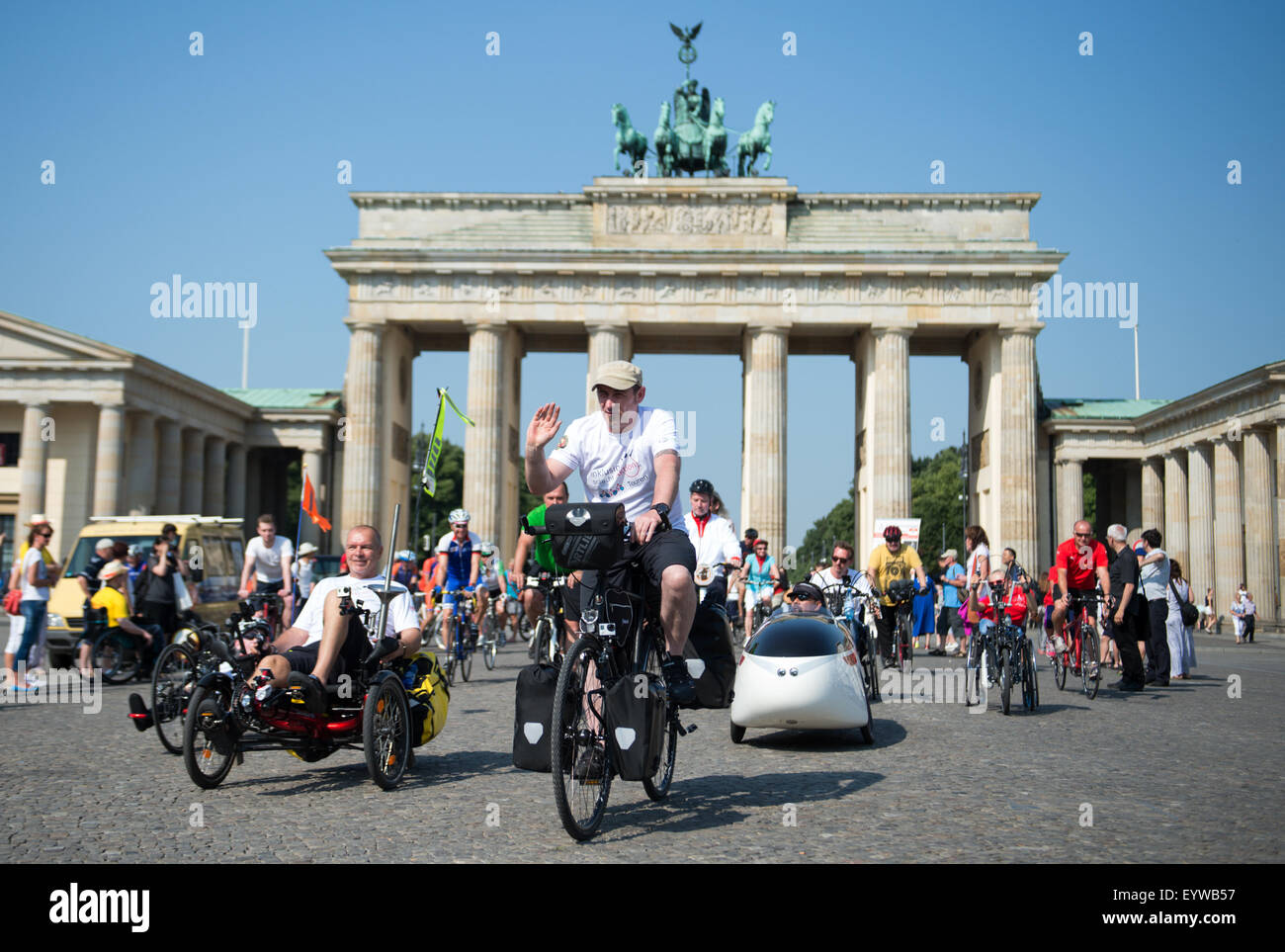 Amateur athletes Karl Grandt (L) from Flensburg and Sven Marx (C) from Berlin embark on their tour, with many people accompanying them on their bicycles, in front of the Brandenburg Gate during the bicycle event 'Inklusion braucht Aktion' (lit. inclusion needs action) in Berlin, Germany, 04 August 2015. With daily stages varying between 80 and 120 km, the 2,700 km tour will take the two men through various European cities and countries such as Flensburg, Berlin, Poland, the Czech Republic, Munich and Austria. Their final destination will be Rome, Italy, where they will have an audience with th Stock Photo