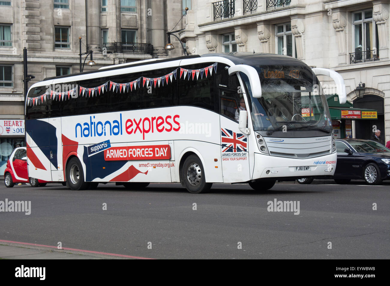 A National Express coach decorated to promote Armed Forces Day passes through Marble Arch towards Victoria Coach station Stock Photo