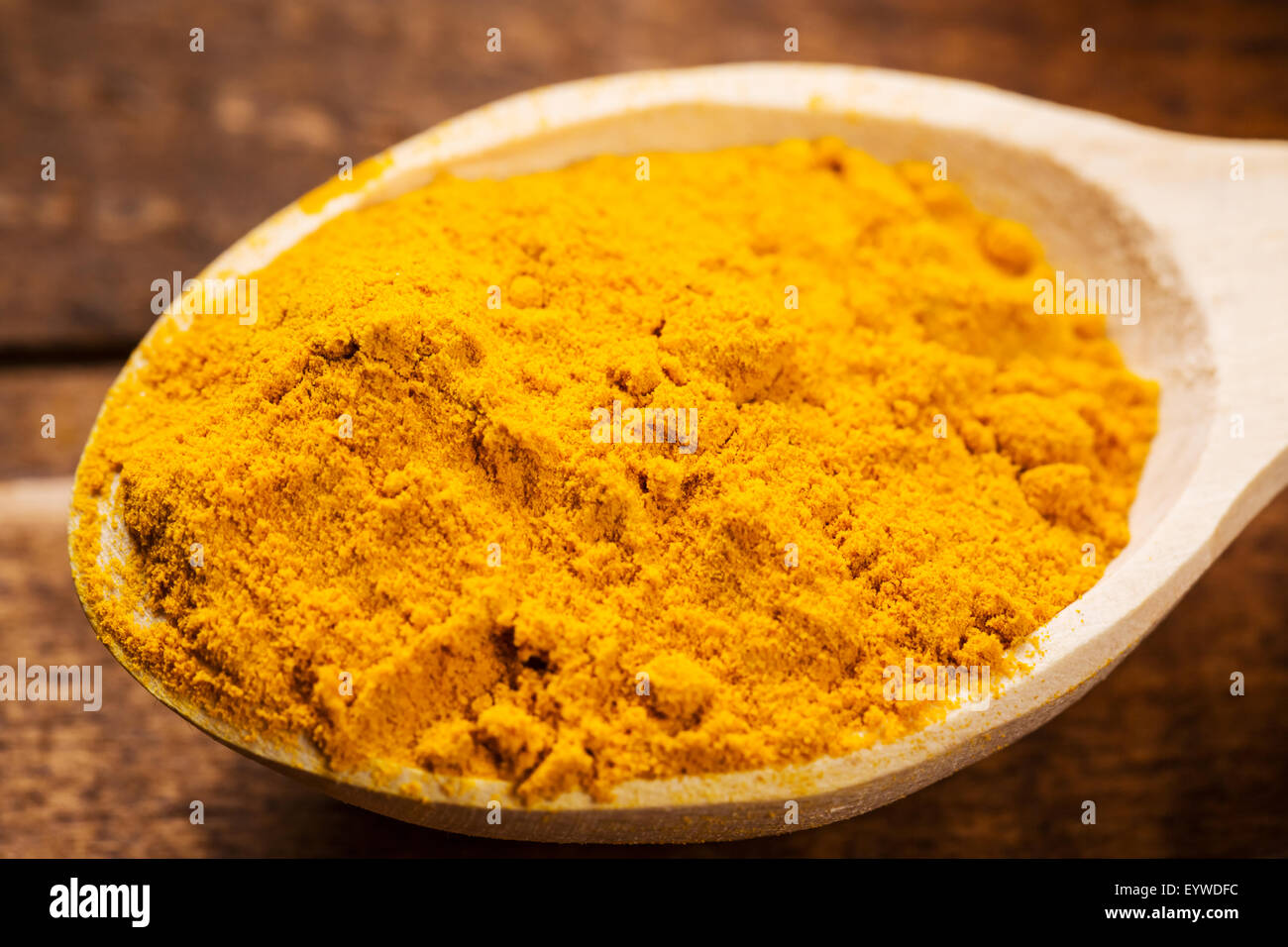 Close up of measuring spoon in pile of organic turmeric (curcuma) powder Stock Photo