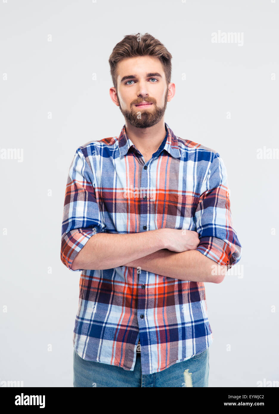 Portrait of a handsome young man standing with arms folded isolated on ...